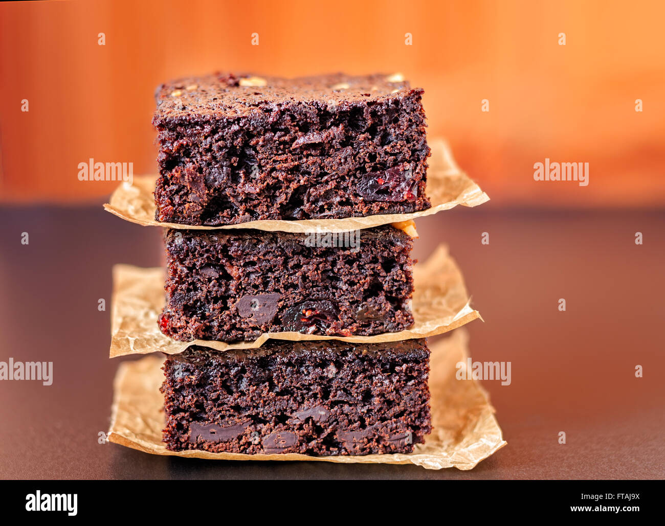 Trois pépites de chocolat brownies empilés sur le papier parchemin. Banque D'Images