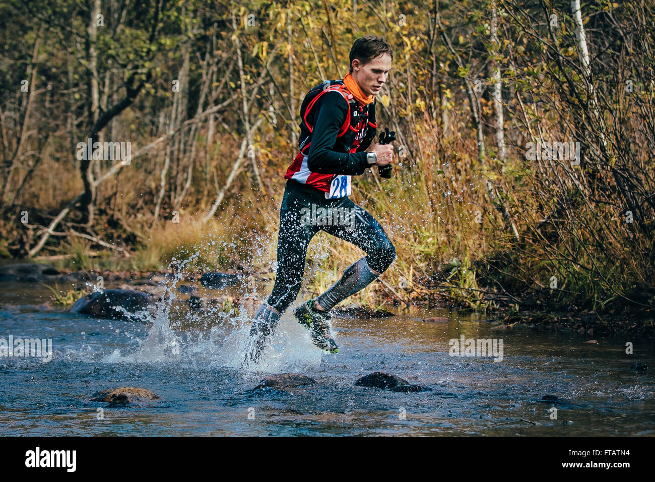 Beloretsk, Russie - le 26 septembre 2015 : Jeune homme runner splash en rivière, au cours d'un passage de la rivière de montagne Banque D'Images