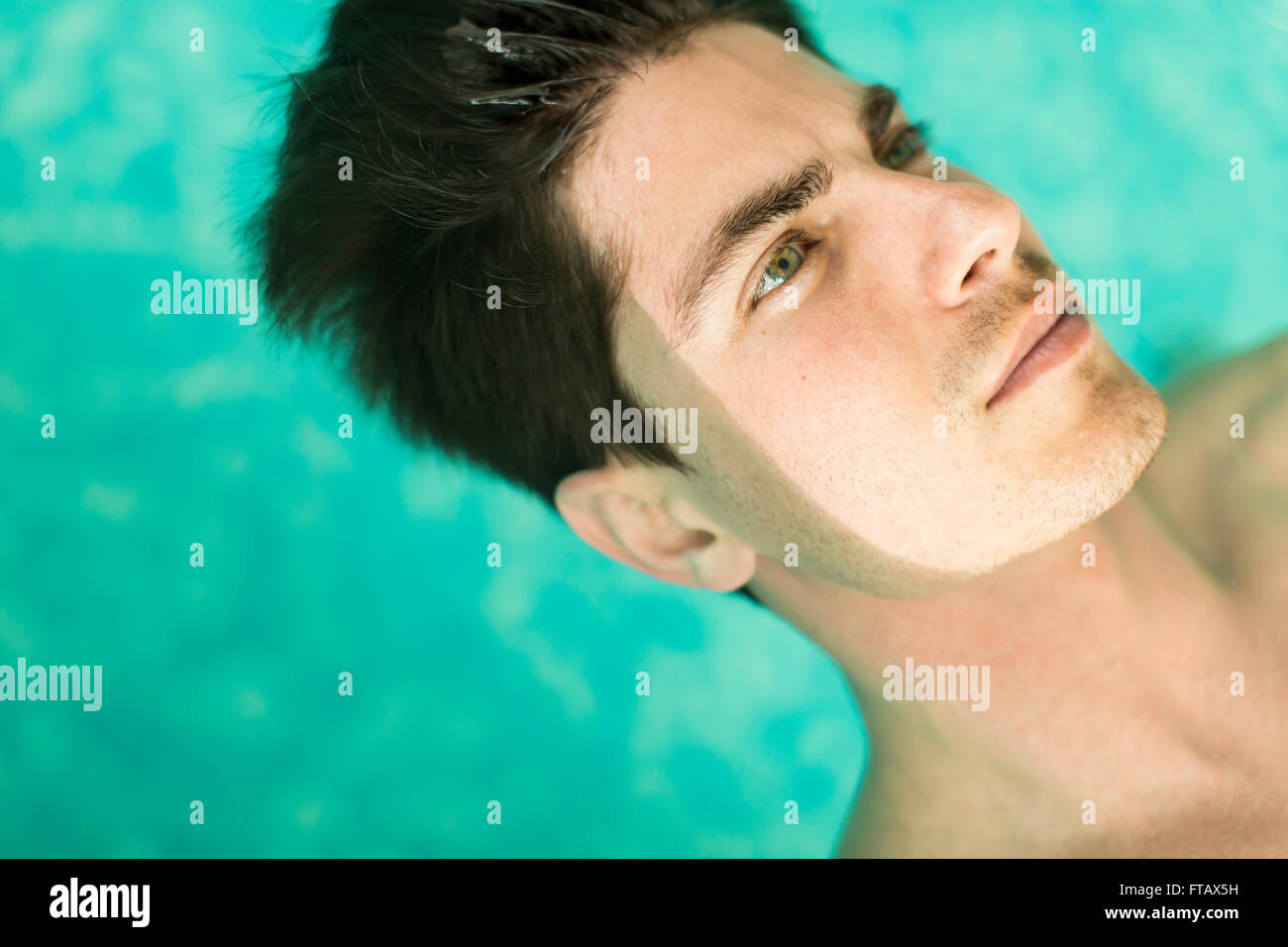 Visage de l'homme flottant dans la piscine Banque D'Images