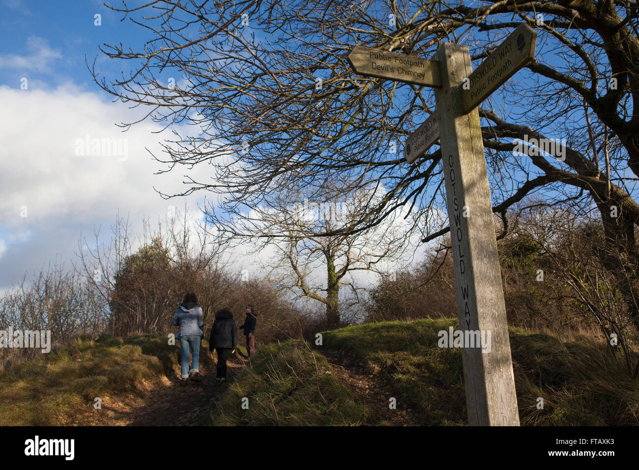 Promenade familiale à Leckhampton hill partie de la façon de Cotswold trhough rout les Cotswolds à Cheltenham au Royaume-Uni. Montre ici un vieux panneau en bois de diriger les marcheurs le long des chemins de l'itinéraire. Banque D'Images