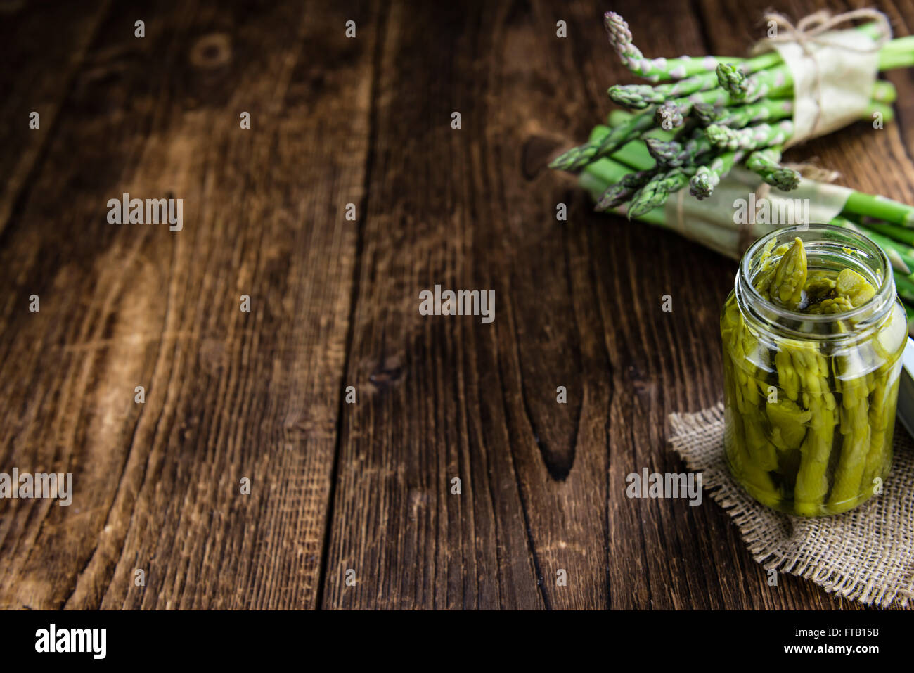 L'asperge verte (conservé) sur une vieille table en bois (selective focus) Banque D'Images
