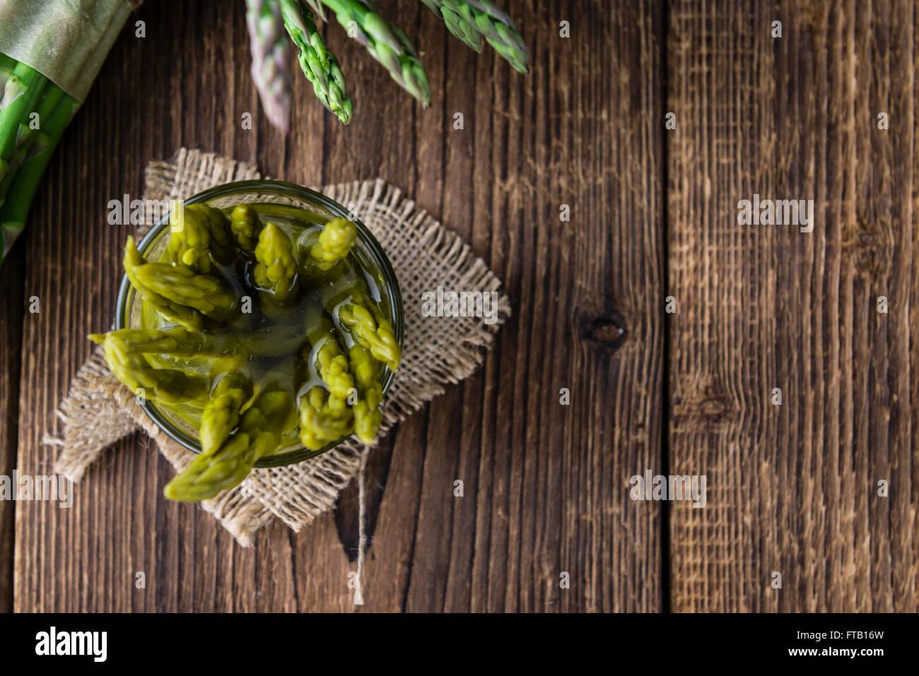 L'asperge verte préservée (selective focus) sur fond de bois Banque D'Images