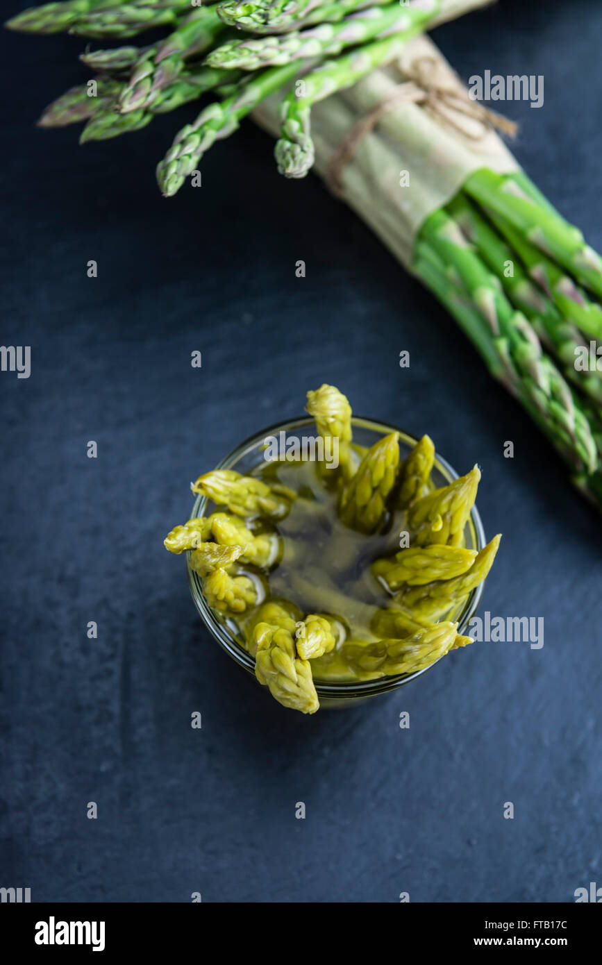 L'asperge verte préservée (selective focus) sur une dalle d'ardoise Banque D'Images