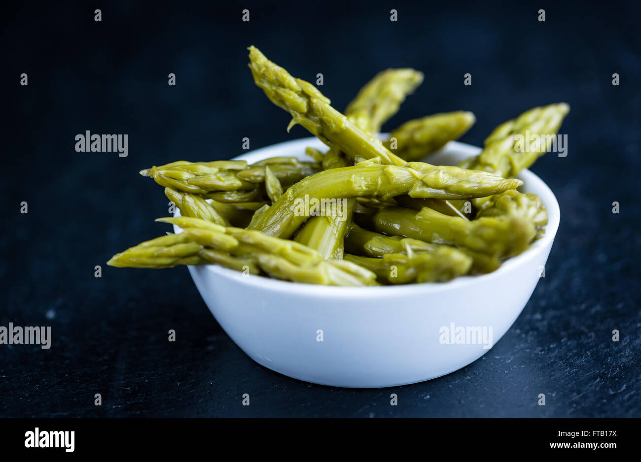 L'asperge verte préservée (selective focus) sur une dalle d'ardoise Banque D'Images