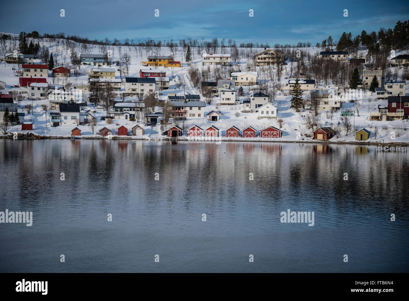 Bateau rouge maisons au bord d'un fjord près de Tromso, Norvège. Banque D'Images