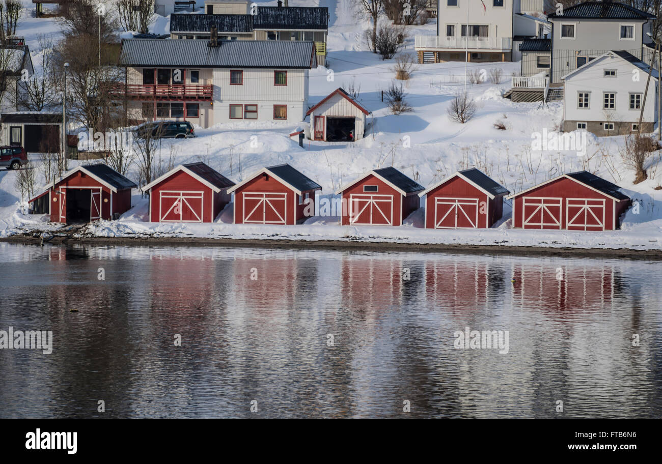 Bateau rouge maisons au bord d'un fjord près de Tromso, Norvège. Banque D'Images