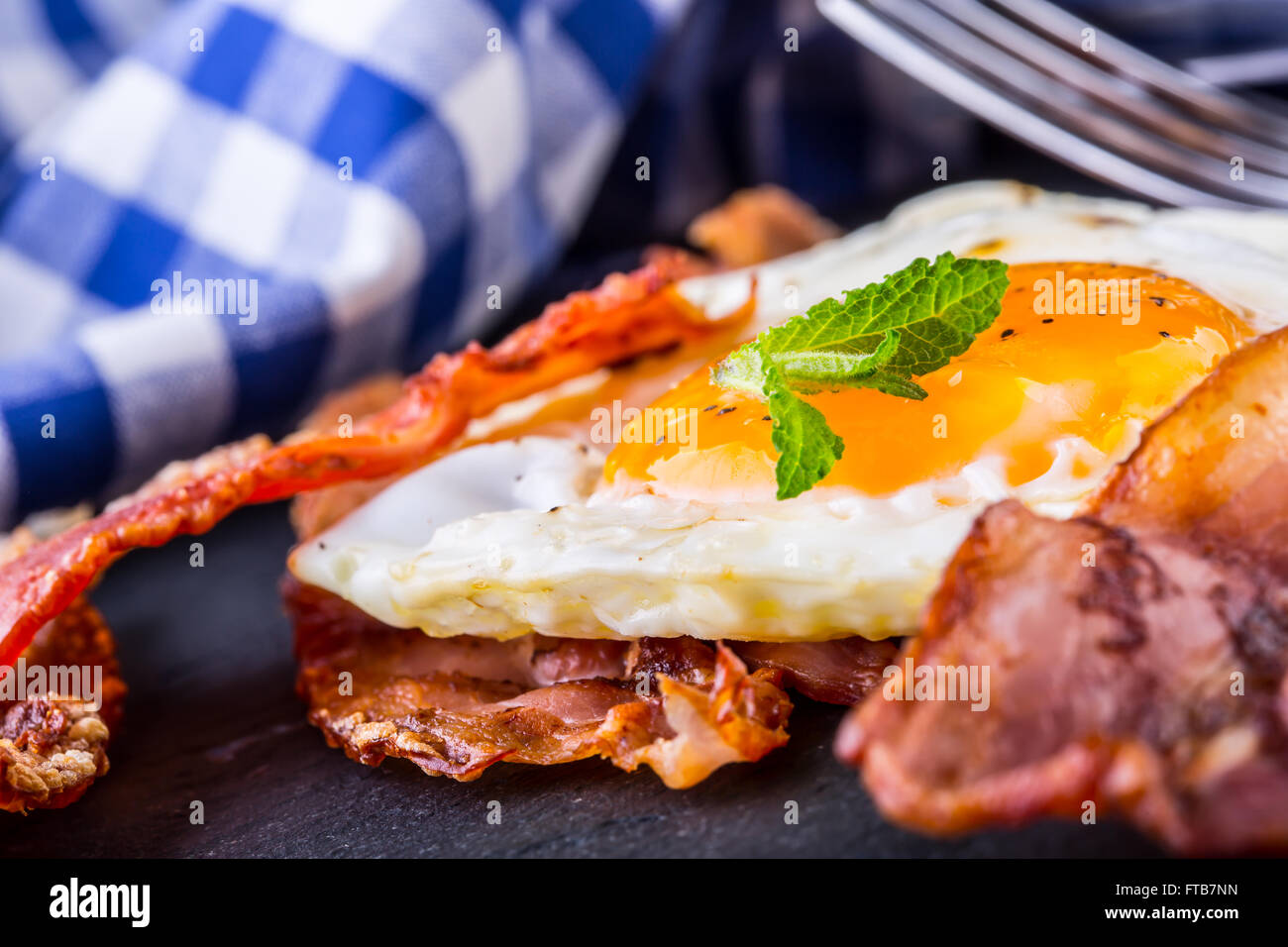 Jambon et oeuf. Bacon et des oeufs. Œuf salé et saupoudré de poivre noir. Petit-déjeuner anglais. Banque D'Images