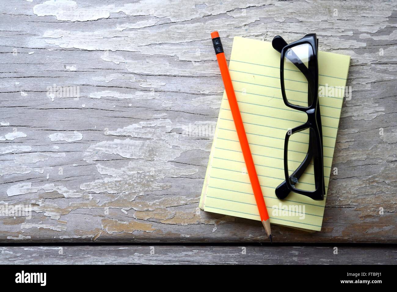 Crayon, lunettes et un bloc-notes sur une table Banque D'Images