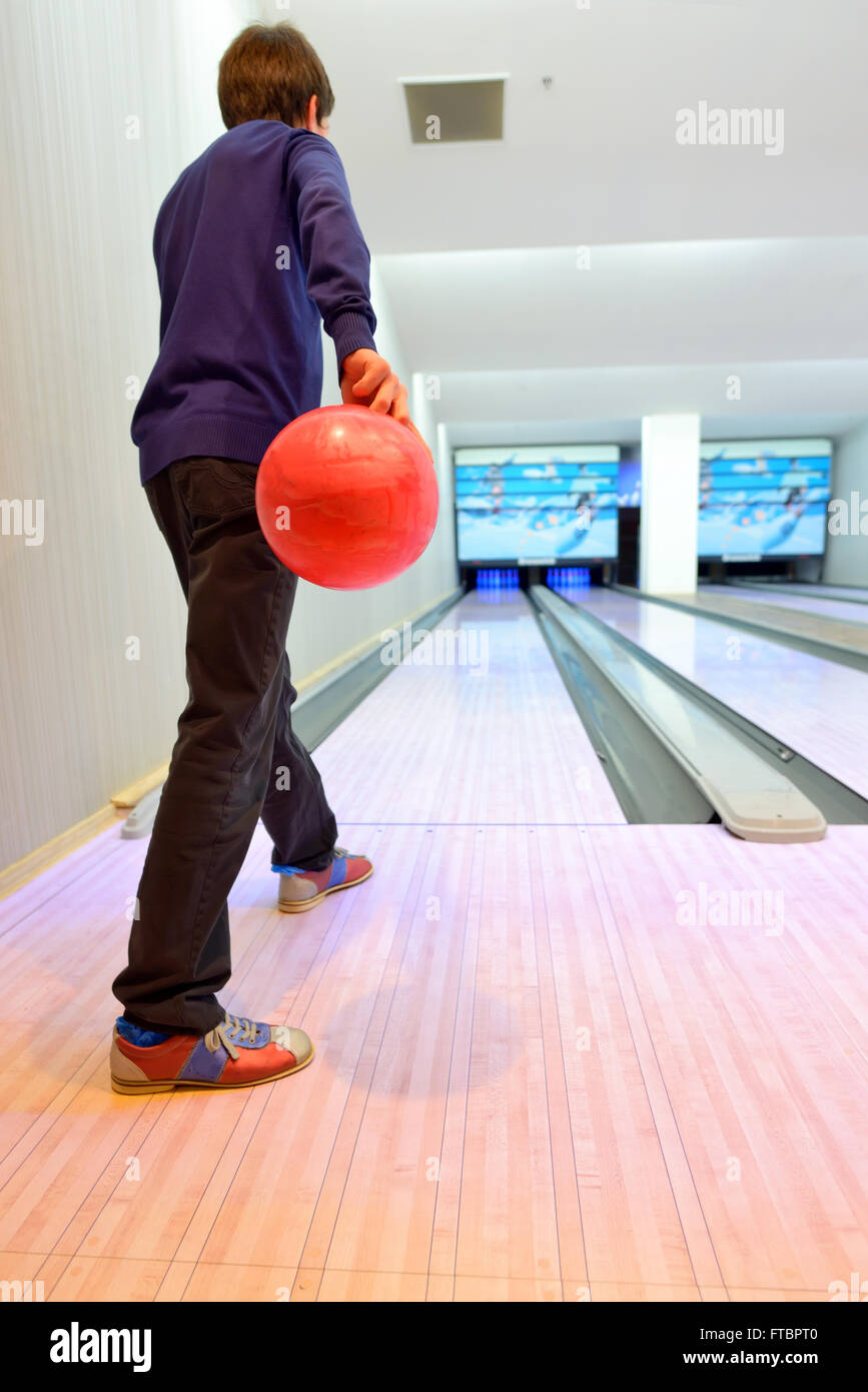 Jeune garçon disposé sur bowling Banque D'Images