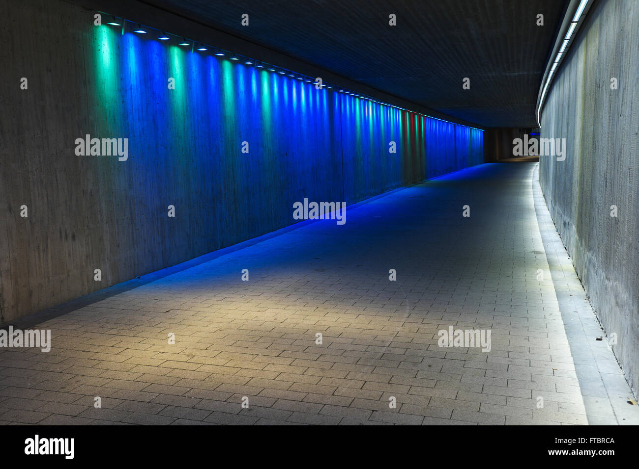 Tunnel en béton souterrain vide avec éclairage coloré Banque D'Images