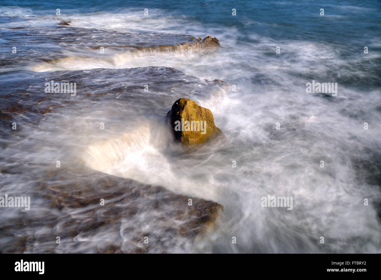 Un rocher dans l'eau swirly Banque D'Images