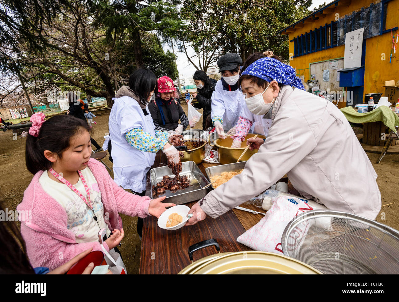 26 mars 2016 - Les gens prennent des mochi, un gâteau de riz japonais traditionnel, au cours d'une manifestation à Yamato City, préfecture de Kanagawa, au Japon. Les gâteaux de riz gluant, faite à partir d'un riz à grain court connu sous le mochigome, sont souvent faites à la nouvelle année, mais peuvent être consommés pendant les fêtes tout au long de l'année. Cet événement a été organisé par un groupe communautaire local pour célébrer les enfants de l'école élémentaire déménagement au niveau suivant, comme l'année scolaire japonaise commence en avril. Un lutteur professionnel local, Keizo Matsuda, a été invité à l'événement pour divertir les enfants et de contribuer à faire du mochi. La rencontre traditionnelle Banque D'Images