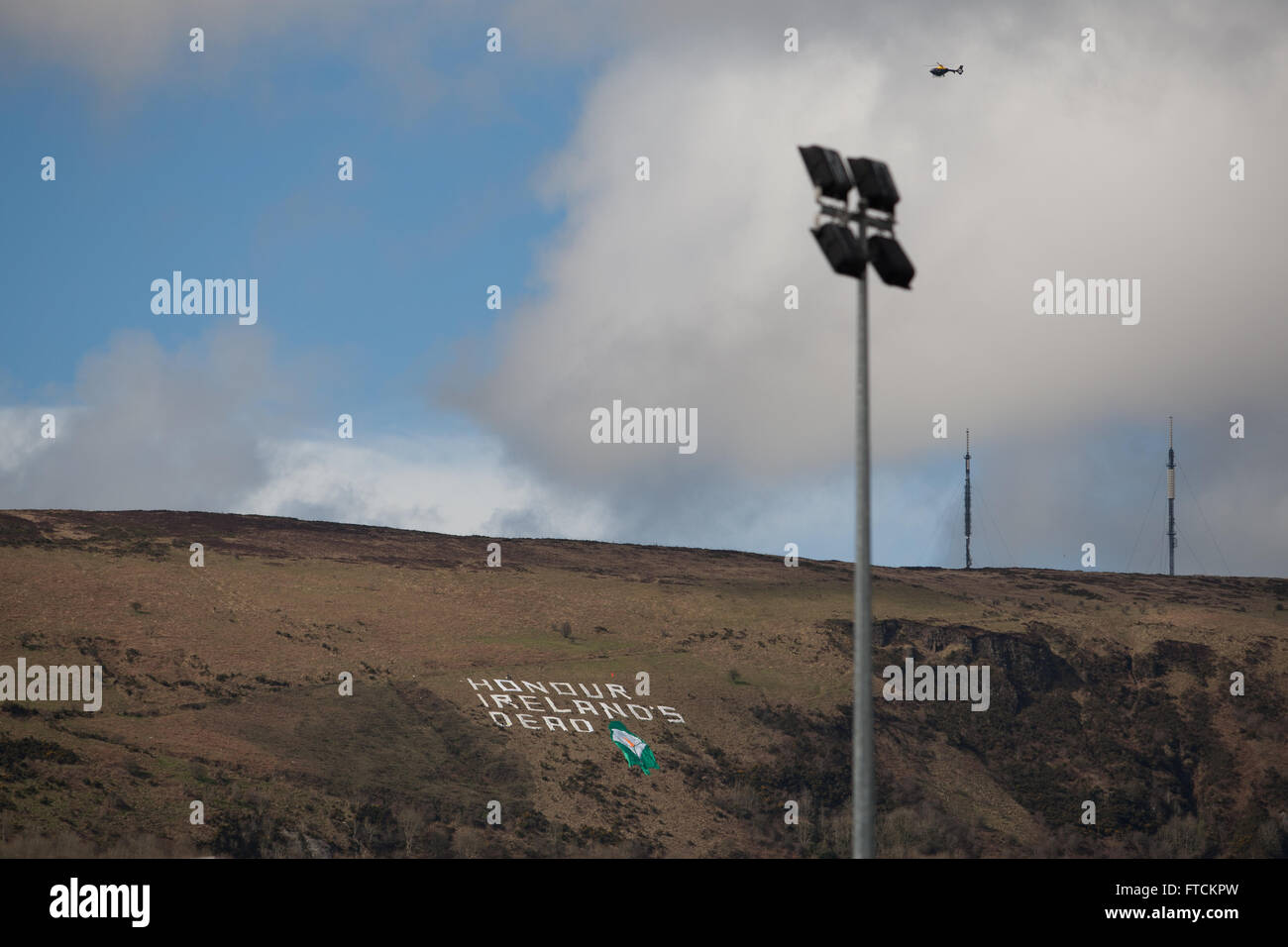 Falls Road, Belfast, Royaume-Uni 27 mars 2016 un grand écran sur le côté d'une colline à côté de Belfast lisez : Honneur Ireland's dead' avec un Lilly à Pâques la hausse du 100e anniversaire Parade Crédit : Bonzo/Alamy Live News Banque D'Images