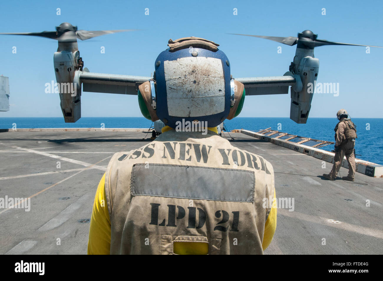 150625-N-WS581-004 MER MÉDITERRANÉE (25 juin 2015) l'Aviation maître de Manœuvre (manutention) 3e classe Benjamin Kimbrough, de Ballwin, Missouri, communique avec une MV-22B Osprey pilote, affecté à l'escadron 365 à rotors basculants moyen maritime (renforcée), à bord du navire quai de transport amphibie USS New York (LPD-21), 25 juin, 2015. USS New York, déployés dans le cadre de l'Iwo Jima Groupe Amphibie/24e Marine Expeditionary Unit, mène des opérations navales dans la sixième flotte américaine Zone d'opérations à l'appui de la sécurité nationale des États-Unis en Europe. (U.S. Photo de la marine par la communication de masse Banque D'Images