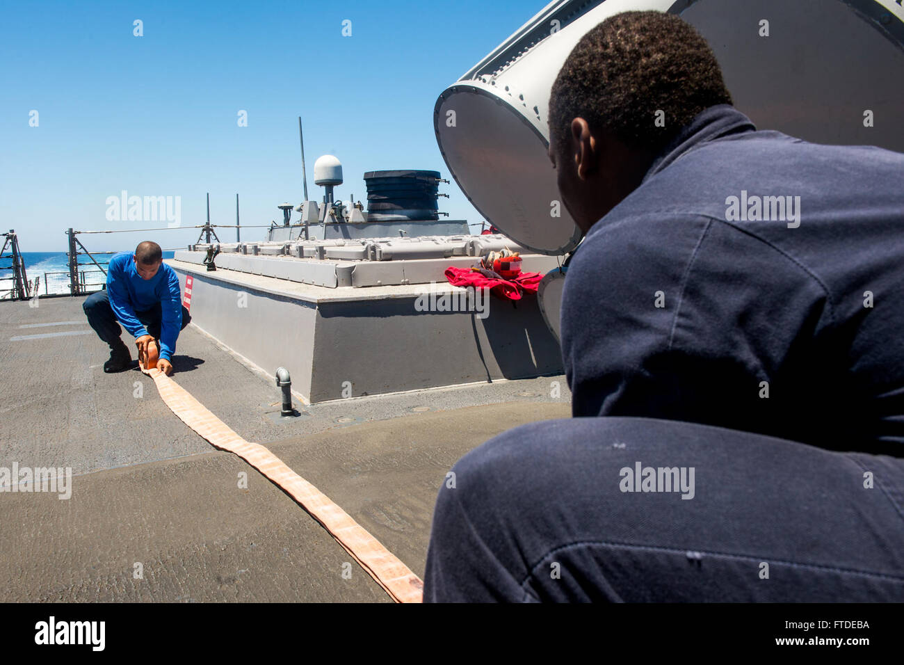 150630-N-EZ054-073 domine la mer (30 juin 2015) Maître de Manœuvre 3 classe Anthony Sanchez, de Hammond, Indiana, roule un tuyau d'incendie pour limiter les dégâts après l'arrimage à bord formation USS Porter (DDG 78), le 30 juin 2015. Porter, une classe Arleigh Burke destroyer lance-missiles, l'avant-déployé à Rota, en Espagne, est sur une patrouille de routine des opérations navales dans la sixième flotte américaine zone d'opérations à l'appui de la sécurité nationale des États-Unis en Europe. (U.S. Photo par marine Spécialiste de la communication de masse 2e classe Luis R. Chavez Jr/libérés) Banque D'Images