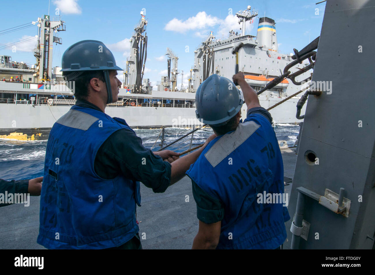 150929-N-AX546-158 MER MÉDITERRANÉE (sept. 29, 2015) Maître de Manœuvre Seaman Apprentice Josh Adams, de Greenfield, Indiana, à gauche, et maître de Manœuvre 3 classe Anthony Sanchez, de Hammond, Indiana, de libérer un fil haute tension à partir d'un oeil du patin à bord de l'USS Porter (DDG 78) au cours d'une reconstitution en cours avec le transport maritime militaire flotte commande reconstitution oiler USNS Leroy Grumman (T-AO 195) 29 septembre, 2015. Porter, une classe Arleigh Burke destroyer lance-missiles de l'avant-déployé à Rota, en Espagne, est en patrouille dans la conduite des opérations navales dans la sixième flotte américaine zone des opérations Banque D'Images
