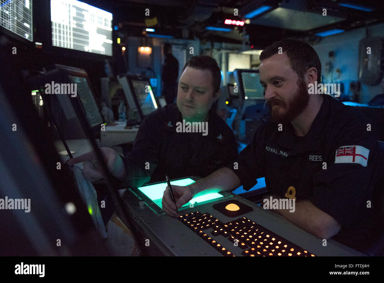 Photo du lieutenant N. Reese de la Royal Navy britannique recevant une mise à jour du contrôleur de la circulation aérienne de 2e classe M. Ferrell à bord de l'USS Harry S. Truman (CVN 75), stationné dans l'océan Atlantique. Le navire soutient les opérations de sûreté maritime. Banque D'Images