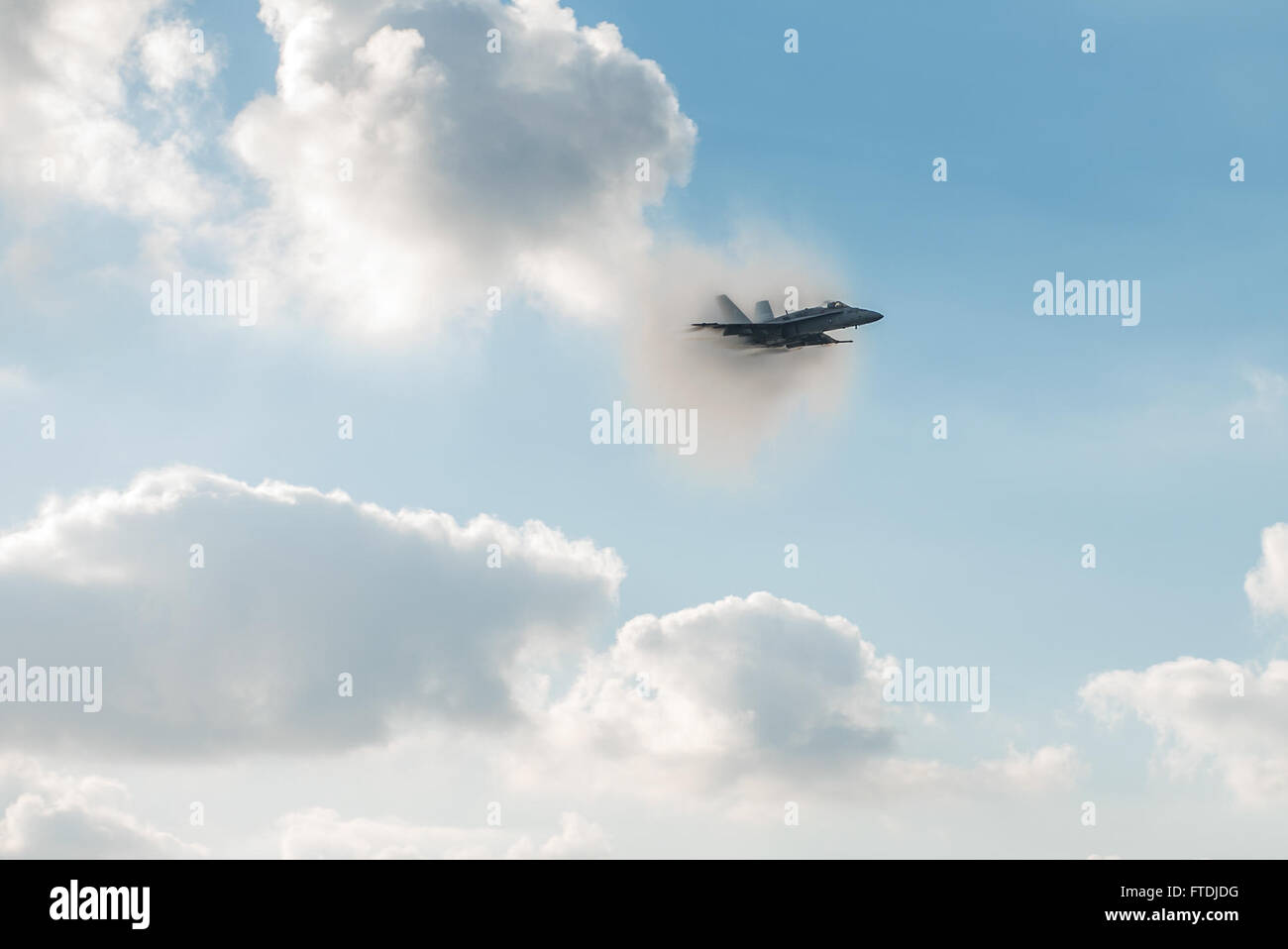 Cette image montre un F/A-18C Hornet brisant le mur du son au-dessus de la mer Méditerranée lors d'une démonstration de l'US Navy. L'avion, qui fait partie du porte-avions USS Harry S. Truman, représente l'aviation militaire avancée et la puissance des forces navales pendant les opérations. Banque D'Images