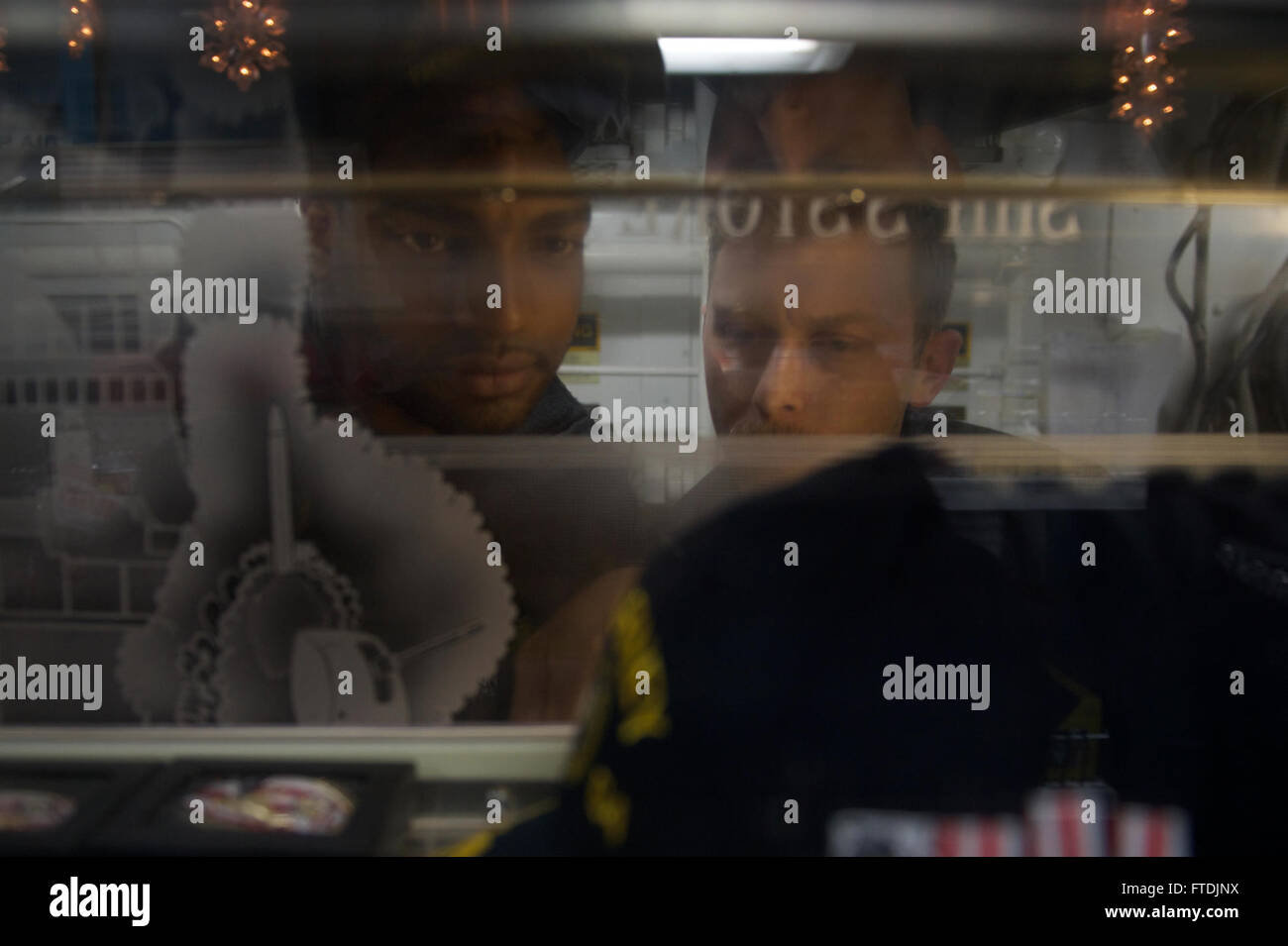 Cette photographie capture le spécialiste des opérations de 1re classe Jermaine Weathers et le pompier de 2e classe J McPherson à bord de l'USS Carney (DDG 64), un destroyer à missiles guidés de classe Arleigh Burke, le 11 décembre 2015. Le navire effectuait une patrouille de routine dans la zone d'opérations de la 6e flotte américaine. Banque D'Images