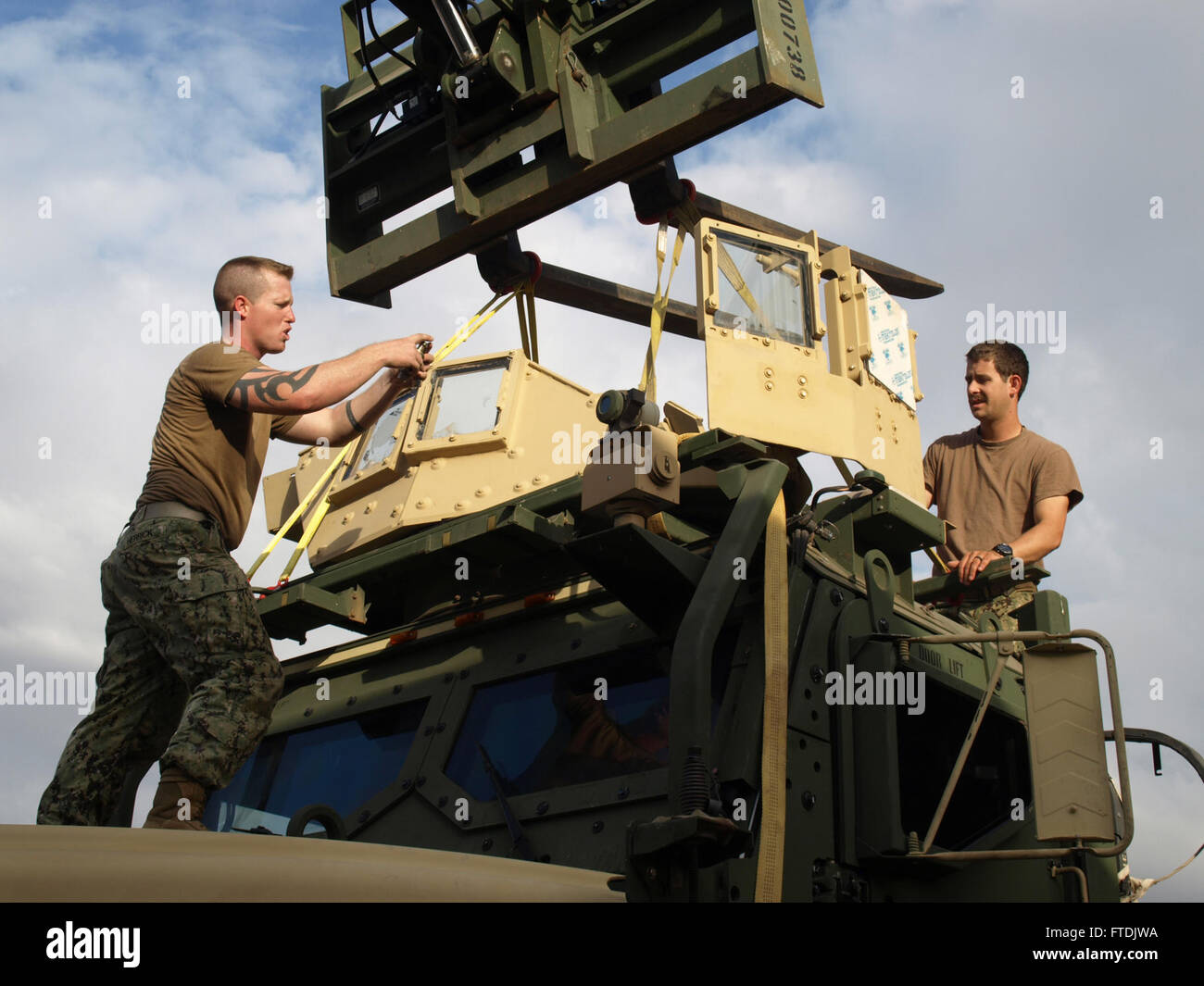Dans cette photo de la marine américaine du 18 décembre 2015, le Master-at-Arms de 1re classe Tyler Herrick et le métallurgiste de 3e classe Andrew Faust installent une tourelle sur un véhicule MTVR au Camp Lemmonier, Djibouti. L'image met en évidence le travail d'équipe impliqué dans les opérations militaires dans la zone de responsabilité de la 6e flotte des États-Unis. Banque D'Images