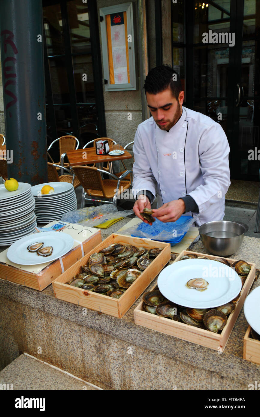 L'homme à l'extérieur restaurant de fruits de mer huîtres tri, Vigo, Galice, Espagne Banque D'Images