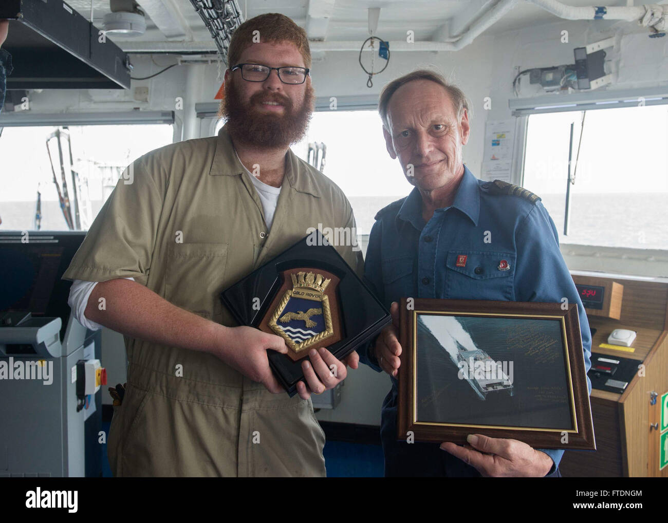 Le capitaine Phil Hanton du Rover auxiliaire Gold de la Royal Fleet échange des cadeaux avec le 3e compagnon Alexander Spitz à bord de l'USNS Spearhead lors de l'exercice Obangame/SaharExpress 2016. L'exercice visait à renforcer la coopération et la sécurité maritimes dans la région du golfe de Guinée. Banque D'Images