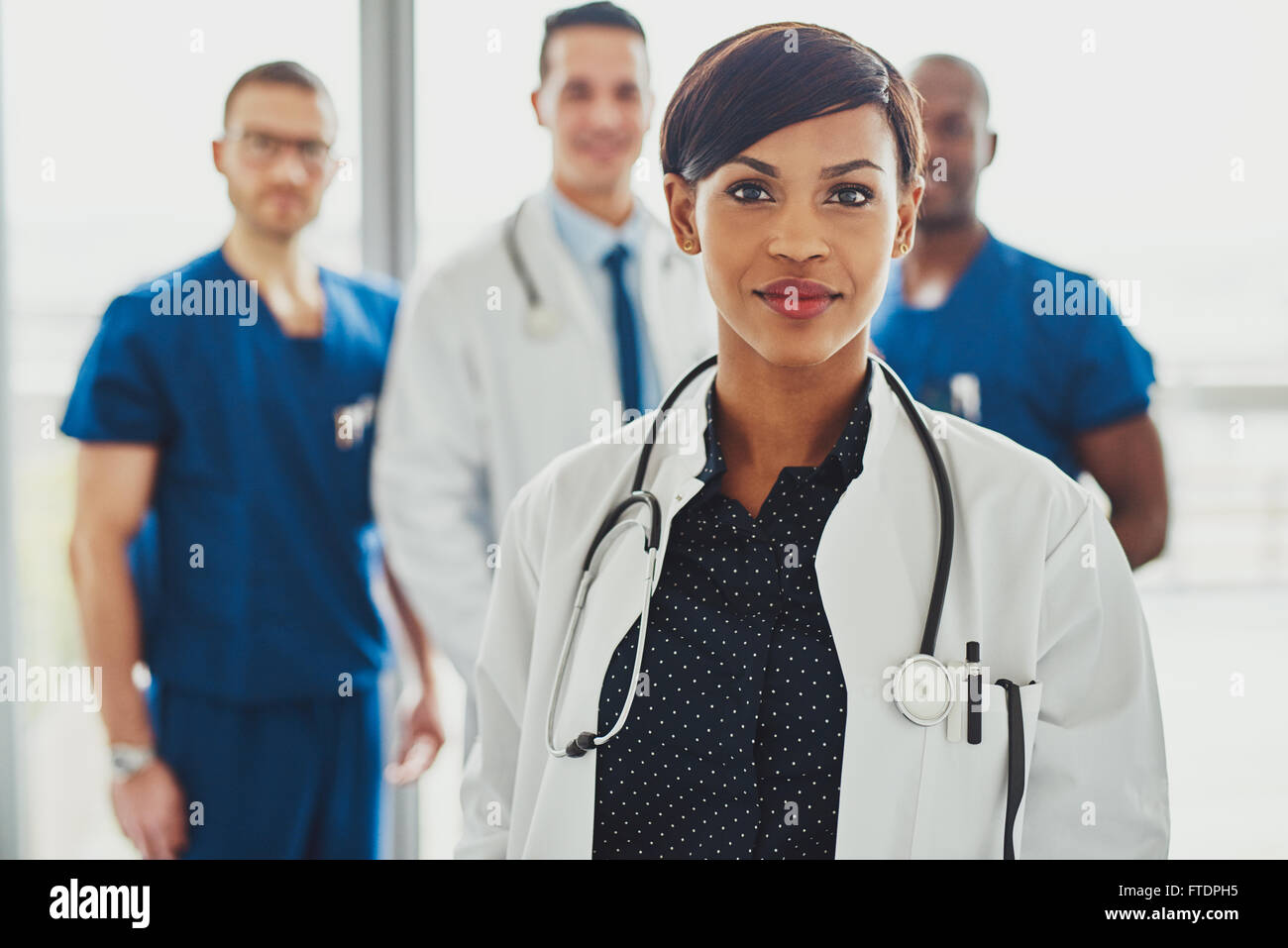 Femme médecin confiant devant team, smiling at camera, de l'équipe multiraciale avec black female doctor Banque D'Images