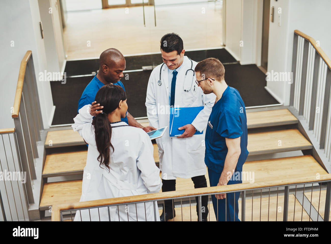 L'équipe de confiance des médecins qui parlent sur un patient à la tablette à Banque D'Images