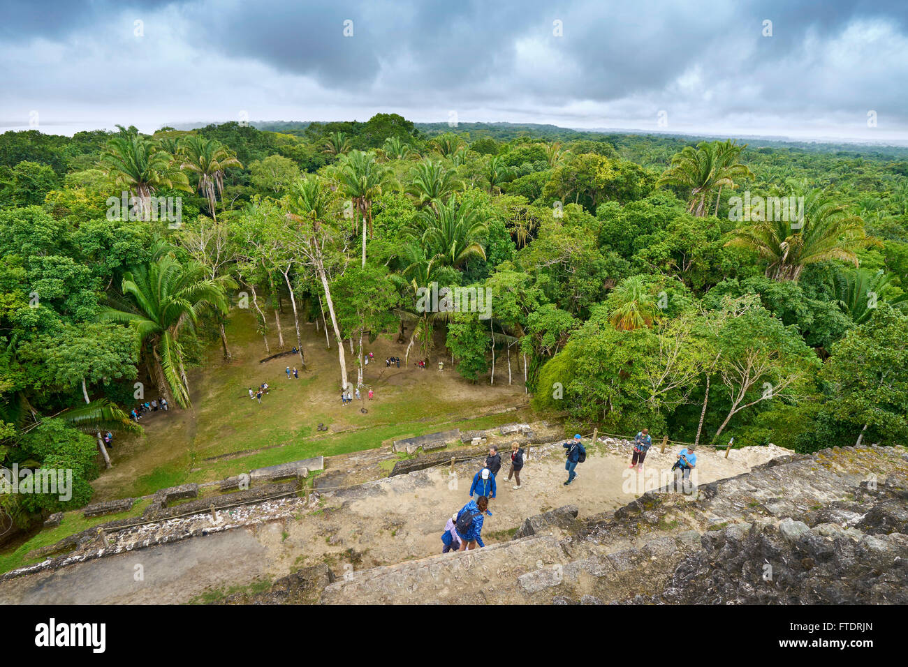 Les touristes admirant vue du Yucatan depuis le haut des ruines du temple, les anciens Mayas, Lamanai, Belize Banque D'Images