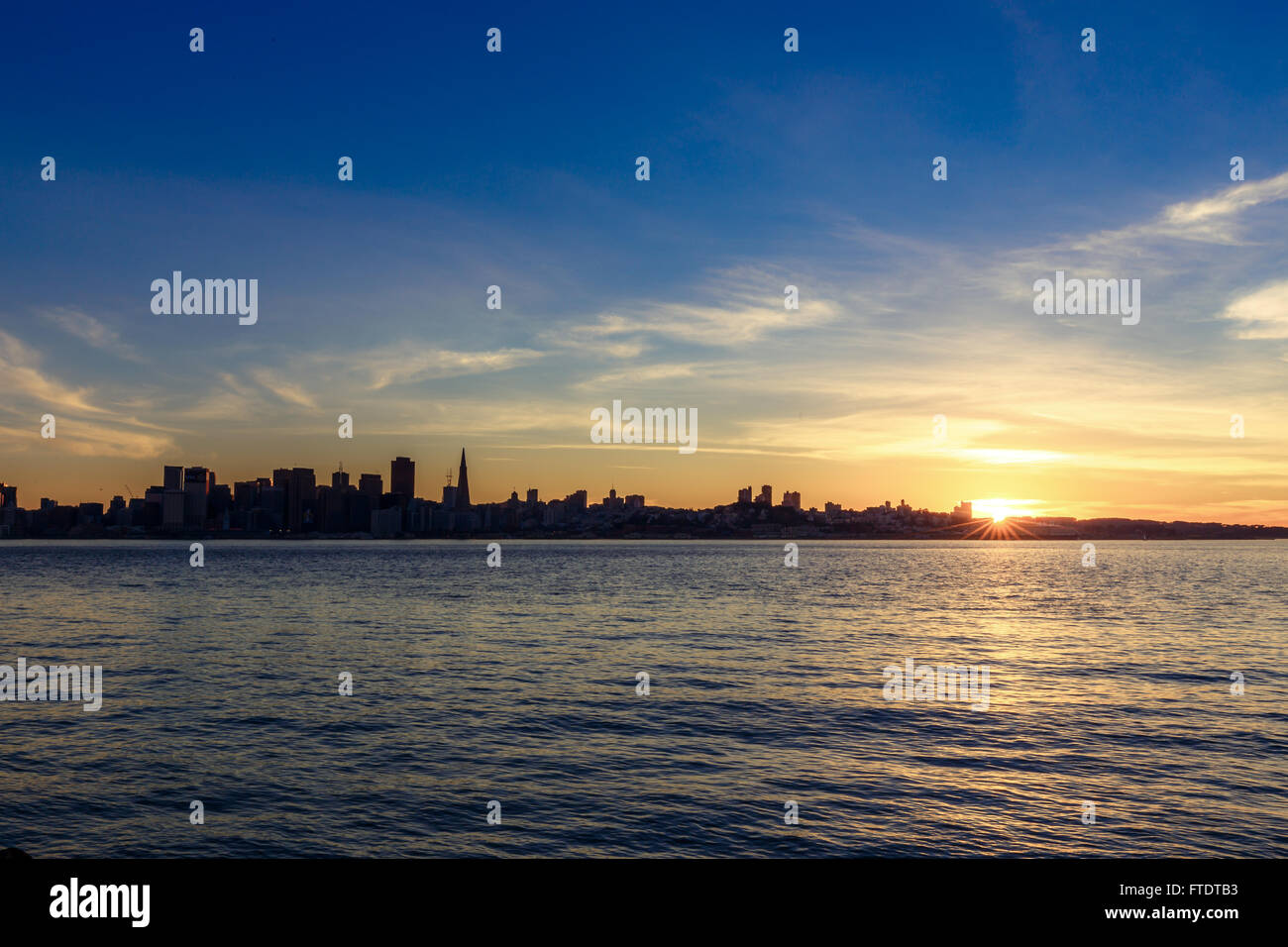 Horizon de San Francisco au coucher du soleil avec une silhouette de gratte-ciel et le Bay Bridge, avec des nuages Banque D'Images