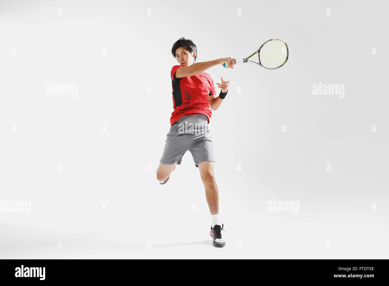 Jeune joueur de tennis japonais en action Banque D'Images