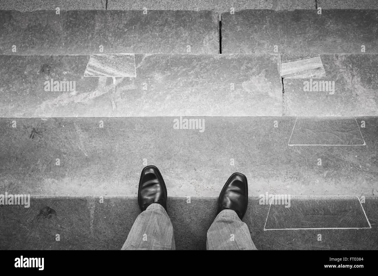 L'homme citadin en noir chaussures en cuir brillant nouveau comité permanent sur les escaliers de pierre en plein air Banque D'Images