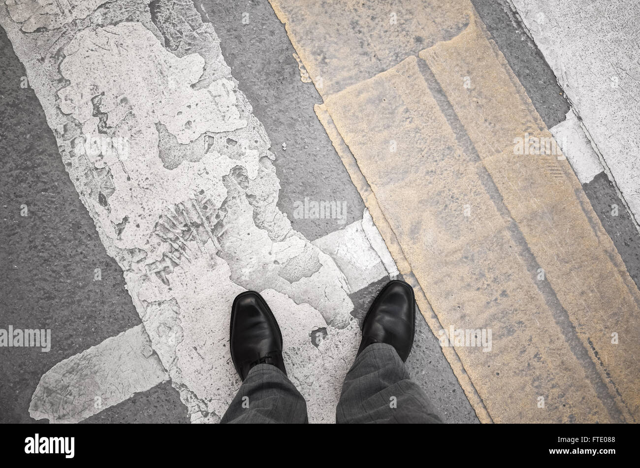 L'homme citadin en noir brillant nouvelles chaussures en cuir sale debout sur le passage pour piétons, signalisation Banque D'Images