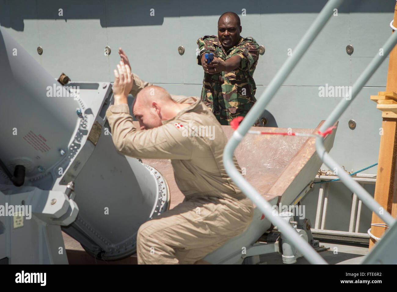 Cette image tirée de l’exercice Cutlass Express 2013 montre un membre d’une équipe d’embarquement tanzanienne emmenant un marin de la Marine royale danoise en détention pendant un exercice d’entraînement à bord du navire de soutien danois HDMS Esberne Snare (l 17). L'exercice visait à améliorer la coopération et la sécurité maritimes en Afrique de l'est. Banque D'Images