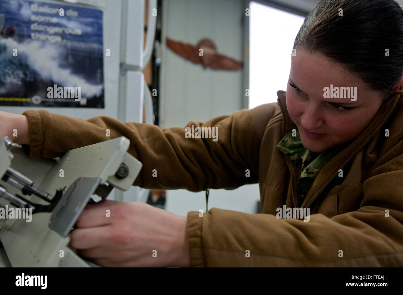 Cette photo capture l'homme de l'aviation Taylor Minton, affecté au 9e escadron de patrouille, réparant un uniforme à la base aérienne navale de Sigonella. La photo souligne l'état de préparation opérationnelle et l'attention portée aux détails du personnel de la marine américaine lors d'un déploiement. Banque D'Images