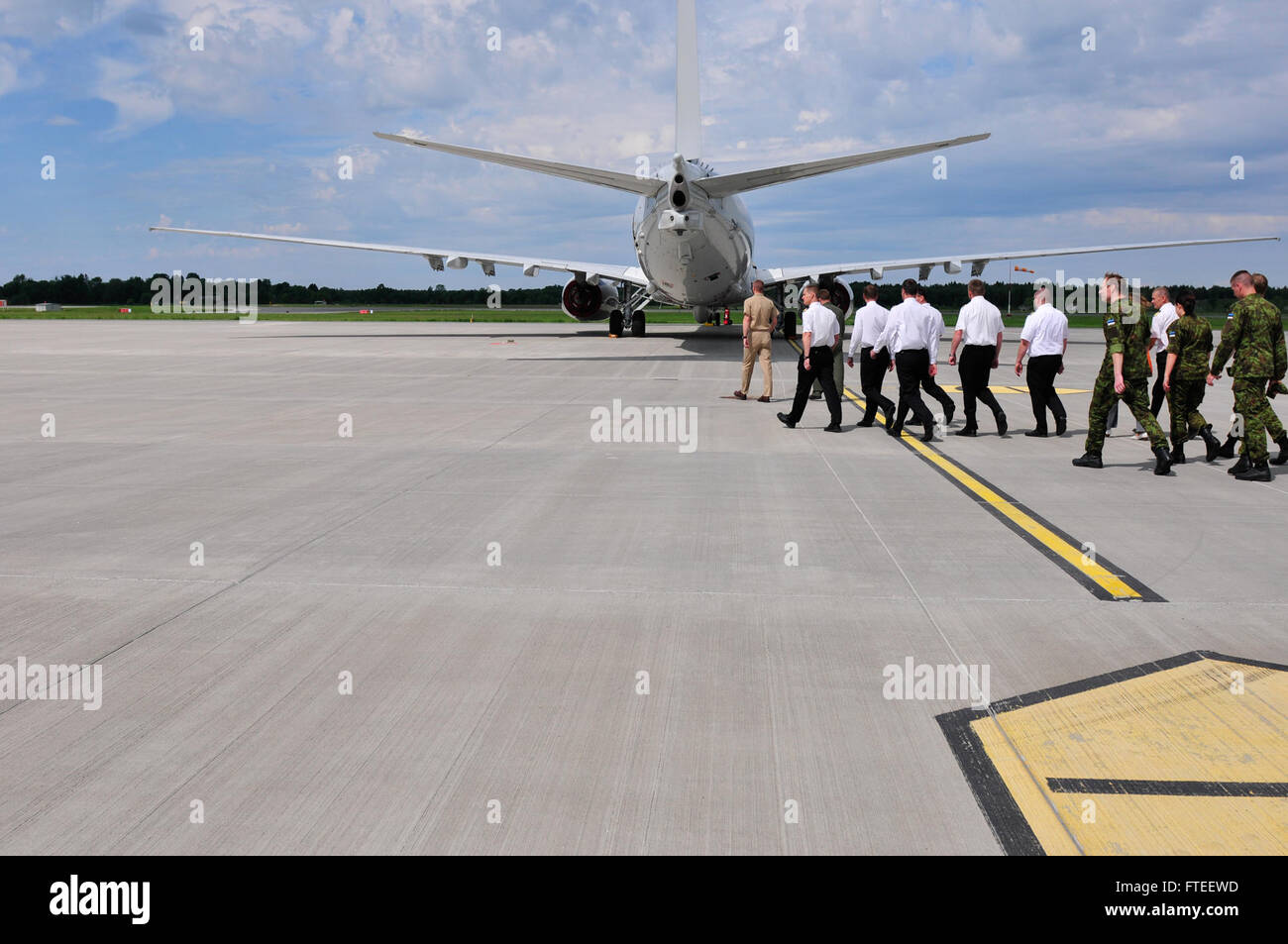 L'image montre Lt. Cmdt. Matthew Olson et des marins estoniens faisant le tour d’un avion P-8A Poséidon pendant l’exercice Baltic Operations (BALTOPS) 2014. L'exercice vise à renforcer les capacités maritimes et à promouvoir la sécurité dans la région de la mer Baltique. Banque D'Images