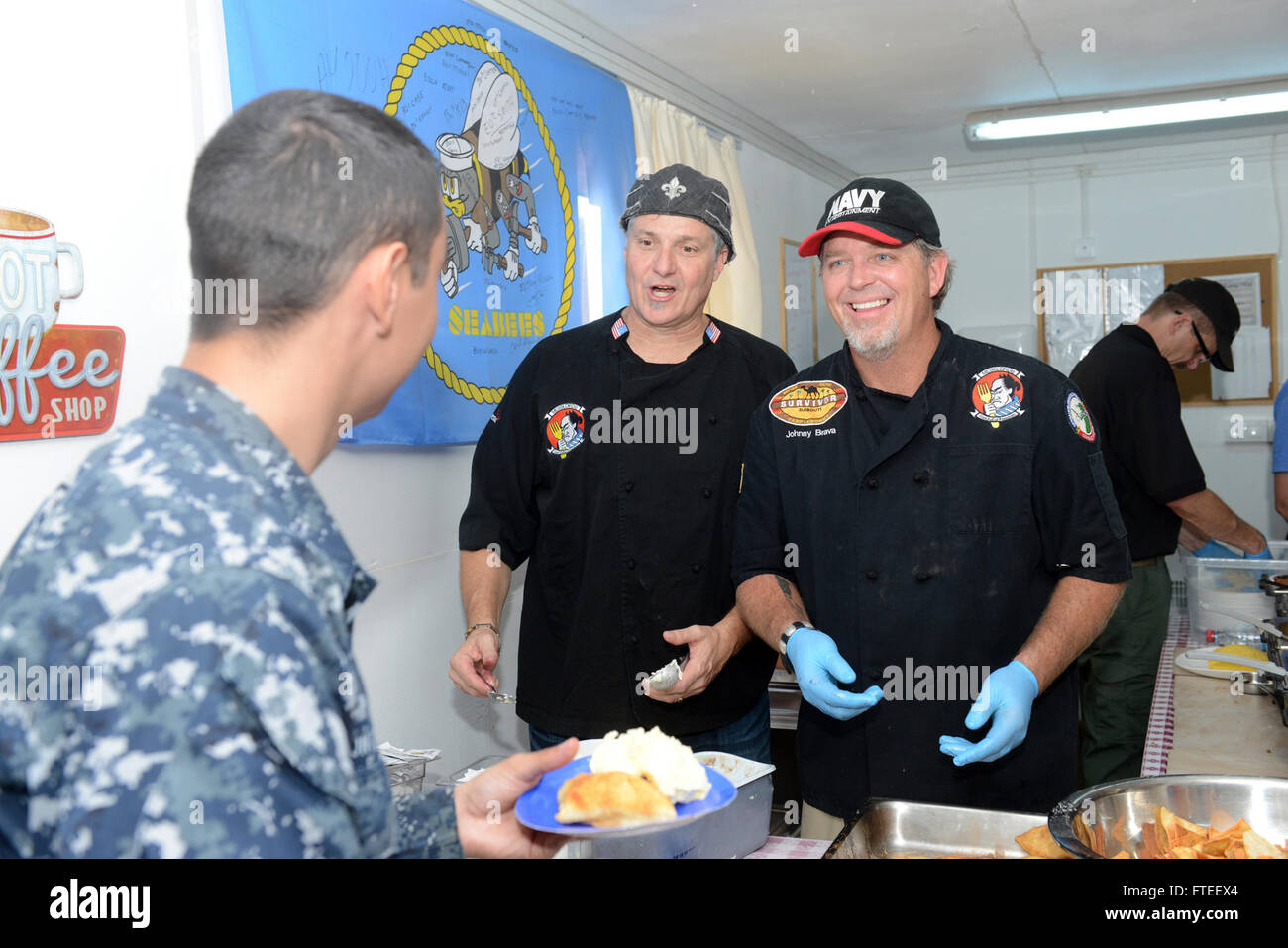 150006-N-LN337-216 DEVESELU, Roumanie (oct. 6, 2015) "chefs" Pete Panini Blohme et John Conley de divertissement célèbre Chef de la marine de l'excursion "Messlords" servir désert pour un marin affecté à l'installation de soutien naval (NSF) Deveselu 6 octobre 2015. Animations de la Marine comme première visite à l'installation, le chef a préparé quatre repas sur une période de 24 heures, le traitement des marins de l'art culinaire gastronomique de grands chefs. NSF est un Deveselu à terre d'installations de la défense antimissile Aegis située au centre-sud de la Roumanie. L'établissement fournit des services de soutien de qualité à l'égide de la rive à terre de défense antimissile Banque D'Images