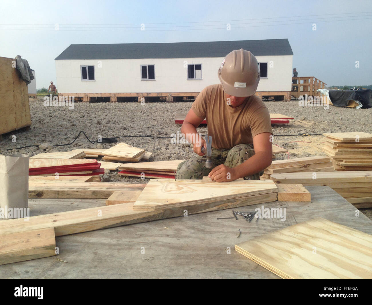 140725-N-ZZ999-002 DEVESELU, la Roumanie (25 juillet 2014) - Constructionman Joshua Parker, affectés à la construction 133 bataillon Mobile, attache à goussets une botte pour installation dans des baraquements temporaires à l'appui de à l'appui de l'Égide à terre la défense contre les missiles balistiques à Deveselu. Un total de 12 casernes fournira l'hébergement et de soutien pour l'égide espaces à terre des forces de sécurité. (U.S. Photo de la marine par le lieutenant J.G. Blaine Henning) Banque D'Images