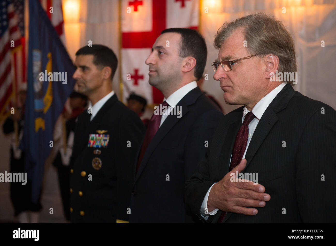 Cette image capture un moment à bord de l'USS Mount Whitney alors que des personnalités clés, dont le capitaine Mark Colombo, commandant de la 6e flotte américaine, le premier ministre géorgien Irakli Garibashvili, et l'ambassadeur américain Richard Norland, honorent l'hymne national américain lors d'une réception. Le navire menait des opérations navales pour soutenir les intérêts américains en Europe. Banque D'Images