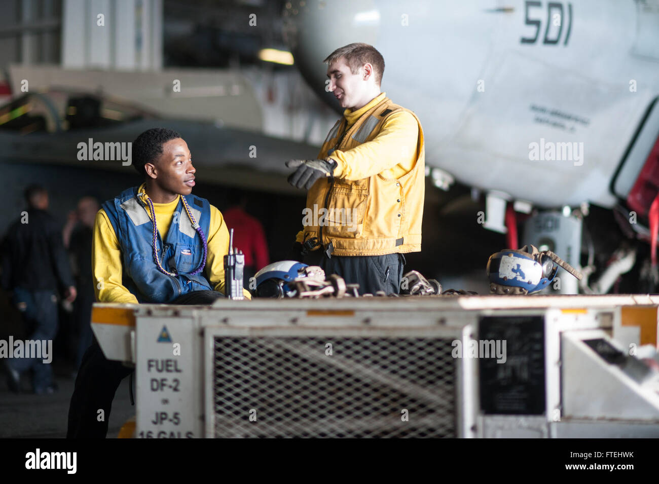 Mer Méditerranée (oct. 29, 2014) l'Aviation maître de Manœuvre (manutention) Airman Edric Ruffin, de Cleburne (Texas), à gauche, et l'Aviation maître de Manœuvre (manutention) Jak Kester, aviateur de Sorting, Wash., aller de l'avion dans le hangar Bay à bord du porte-avions USS George H. W. Bush (CVN 77). George H. W. Bush, homeported à Norfolk, Va., mène des opérations navales dans la sixième flotte américaine zone d'opérations à l'appui de la sécurité nationale des États-Unis en Europe. Banque D'Images