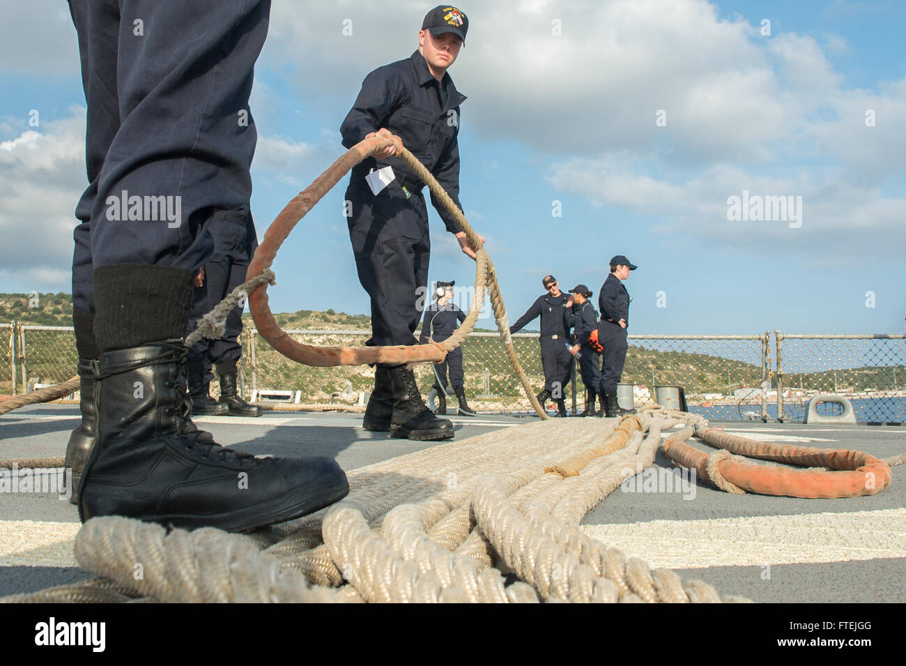 La baie de Souda, la Grèce (31 déc. 4, 2014) - Les marins à bord de l'USS Cole (DDG 67 bobines) et la ligne d'amarrage se replie à mesure que le navire quitte la baie de Souda à la suite d'une escale prévue le 4 décembre 2014. Cole, une classe Arleigh Burke destroyer lance-missiles, homeported à Norfolk, mène des opérations navales dans la sixième flotte américaine zone d'opérations à l'appui de la sécurité nationale des États-Unis en Europe. Banque D'Images