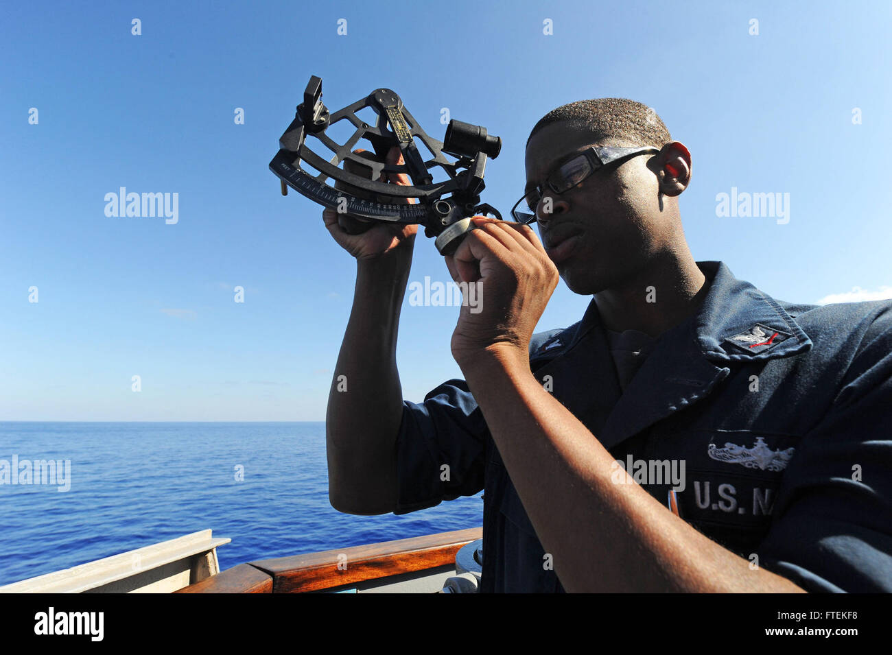 Quartier maître de 3e classe Nicholas Easter fait une démonstration de navigation céleste à bord de l'USS Ramage (DDG 61) en Méditerranée. L’utilisation d’un sextant fait partie des techniques traditionnelles de navigation navale, assurant un positionnement précis lors des opérations. Banque D'Images
