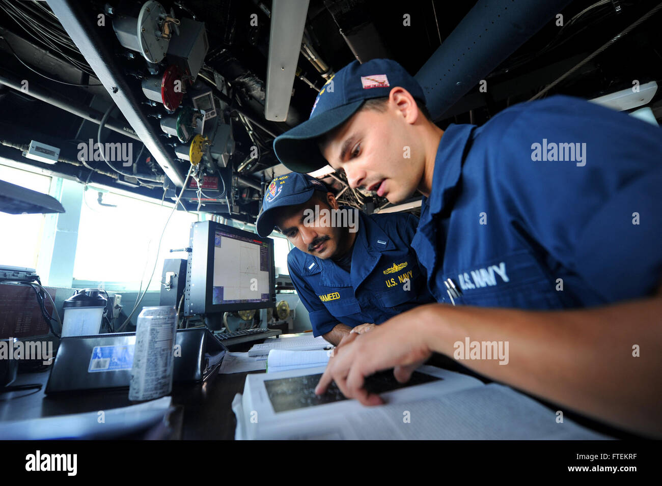 Cette photographie montre Lt.j.g. Zishan Hameed et l'apprenti matelot de quartier-maître Pasquale Verrastro à bord de l'USS Ramage (DDG 61) alors qu'ils discutent de la navigation céleste dans la maison de pilotage. L'image a été capturée lors d'un déploiement à l'appui des opérations de sécurité maritime américaines en mer Méditerranée. Banque D'Images