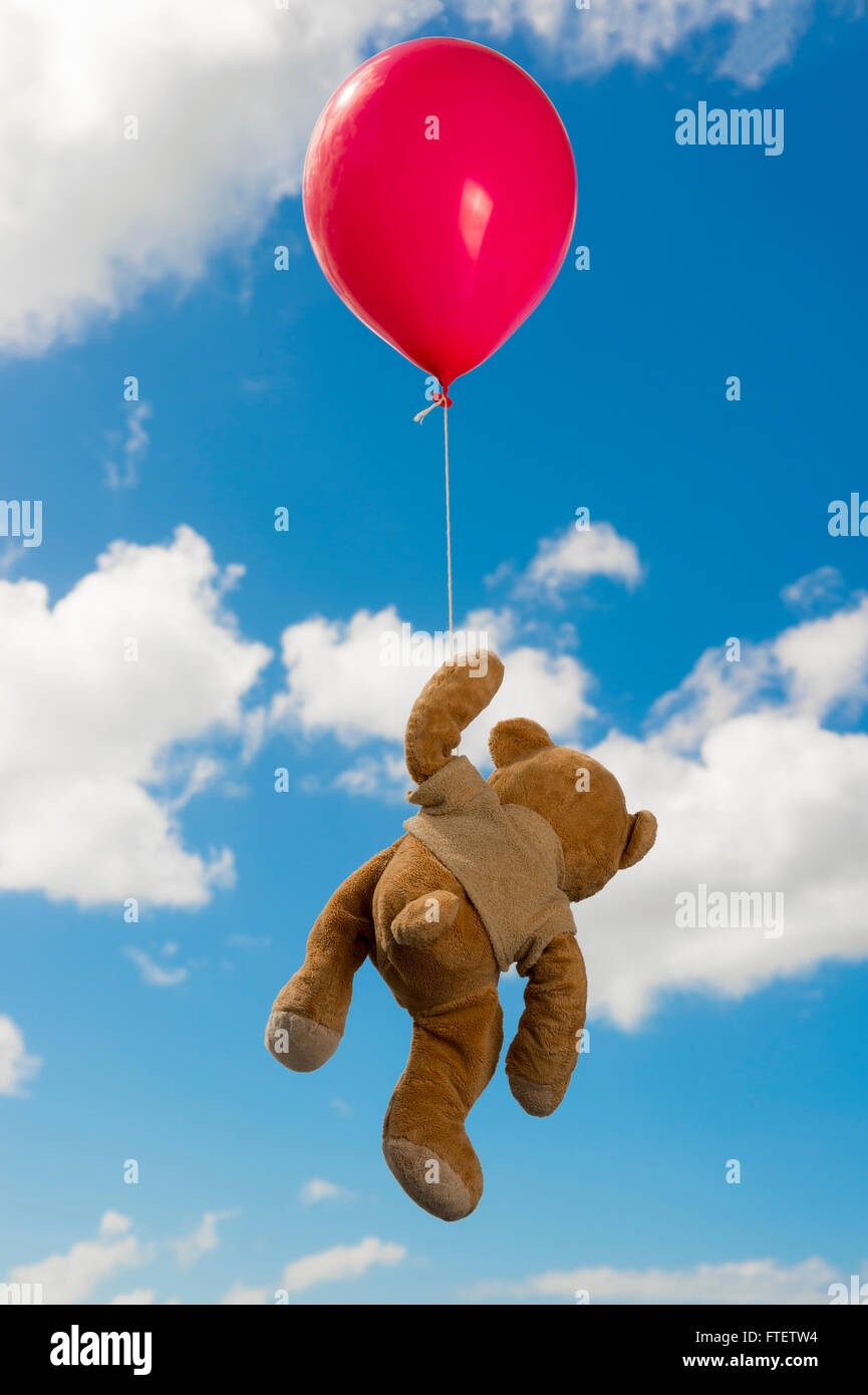 Vue arrière d'un ours en peluche suspendu à un ballon par sa patte Banque D'Images