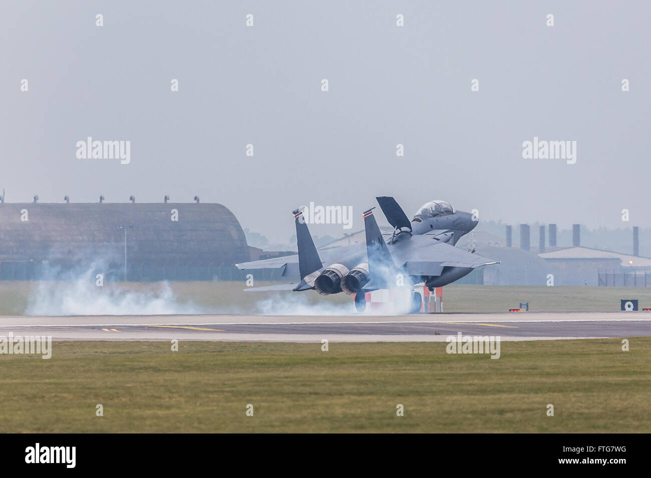 Bouffées de fumée à partir des pneus d'un Strike Eagle qu'il atterrit à RAF Lakenheath Banque D'Images