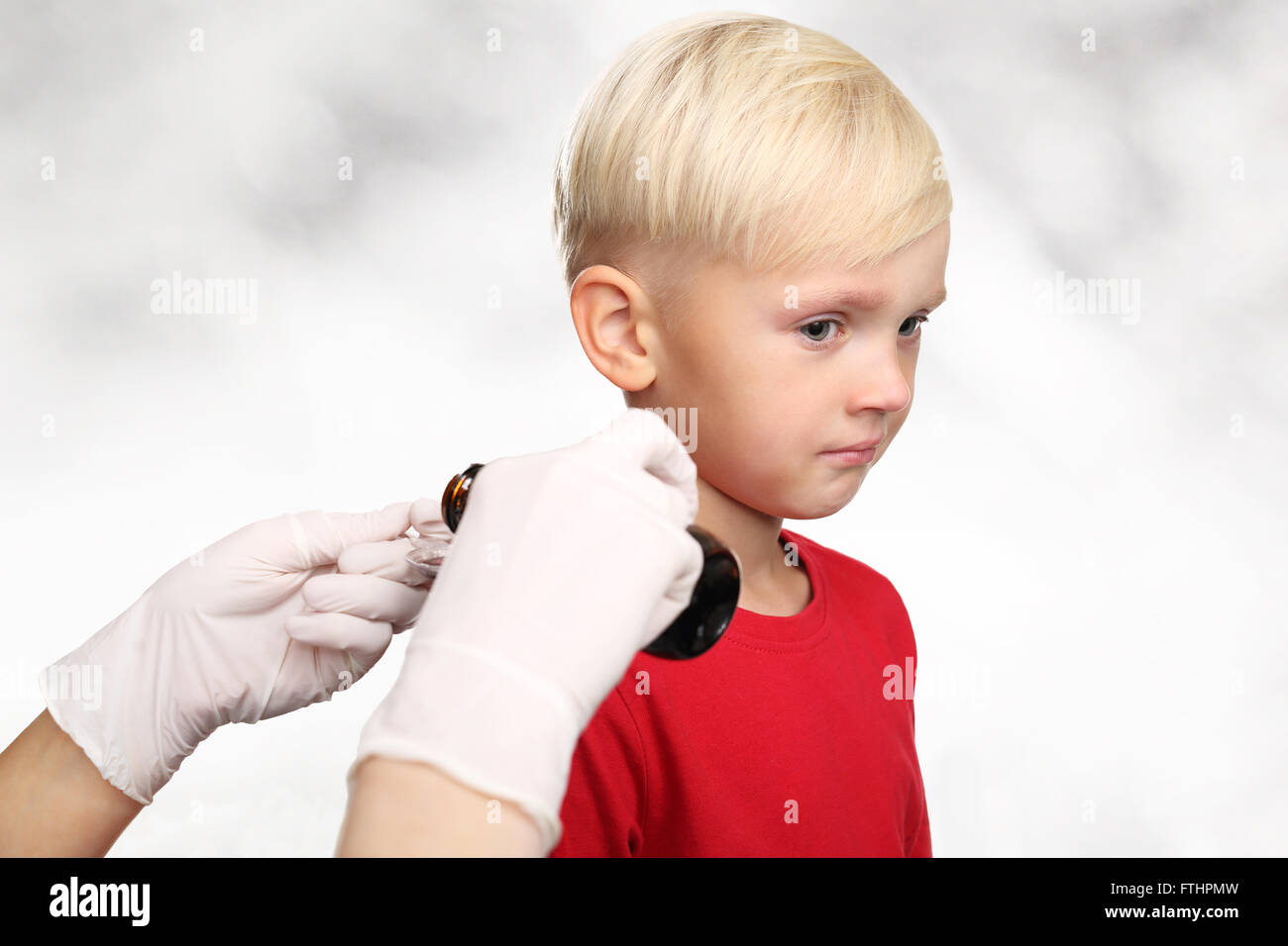 C'est terrible ! Le garçon ne veut pas boire la médecine. Un enfant avec un médecin, un traitement pour la grippe. Banque D'Images