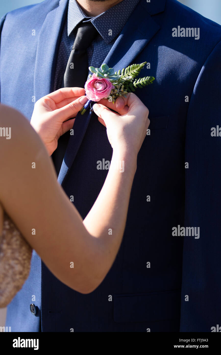 L'épinglage mariée une boutineer sur son fiancé le jour de leur mariage dans l'Oregon. Banque D'Images