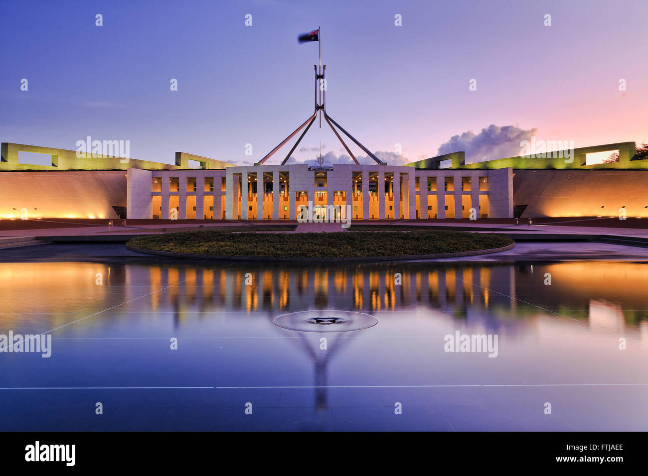 Reflet de couleur Canberra dans le nouveau bâtiment du parlement dans un étang fontaine au coucher du soleil. Banque D'Images