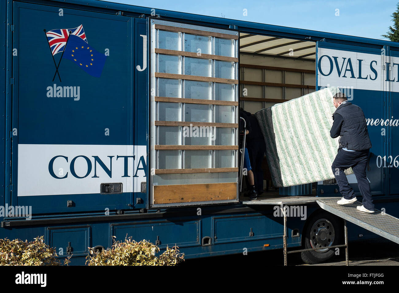 L'homme dépose un matelas de chargement dans un camion. Banque D'Images