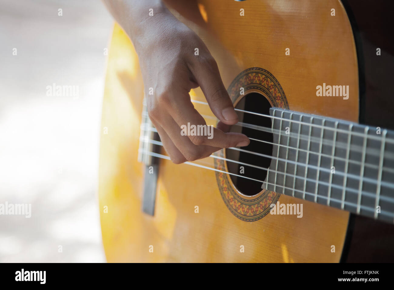 Main femme jouant une guitare acoustique libre Banque D'Images